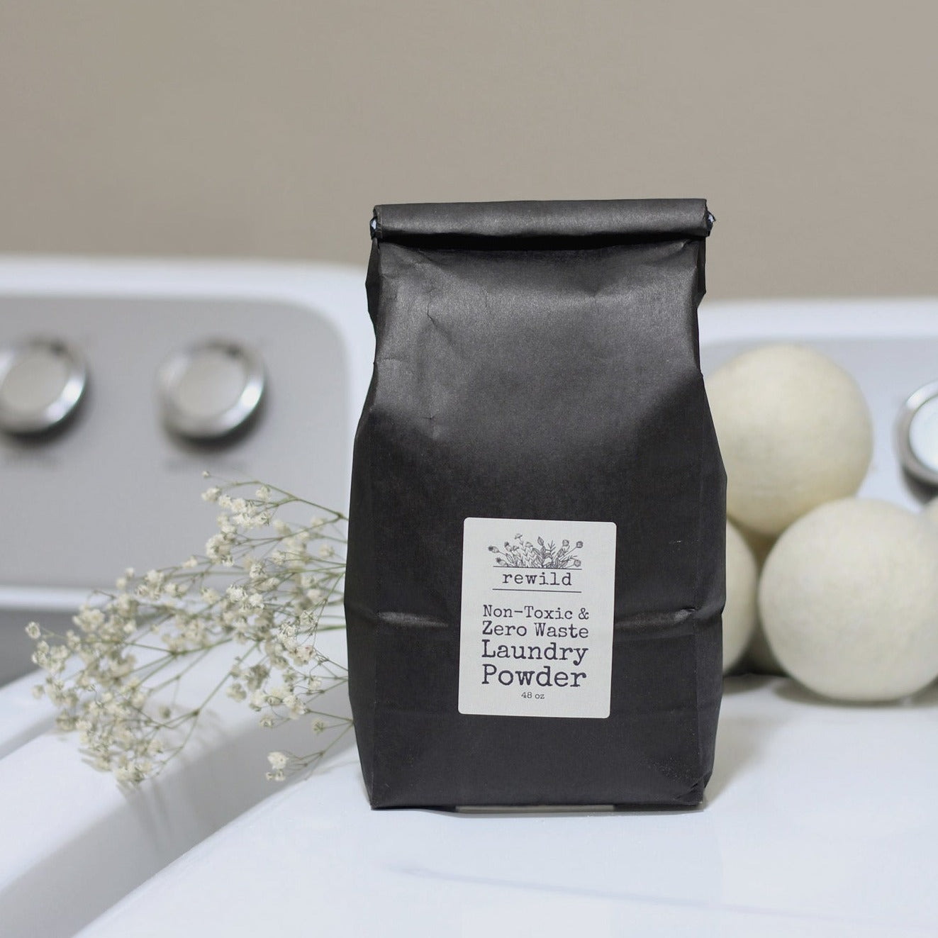black paper bag of laundry powder sitting on washer