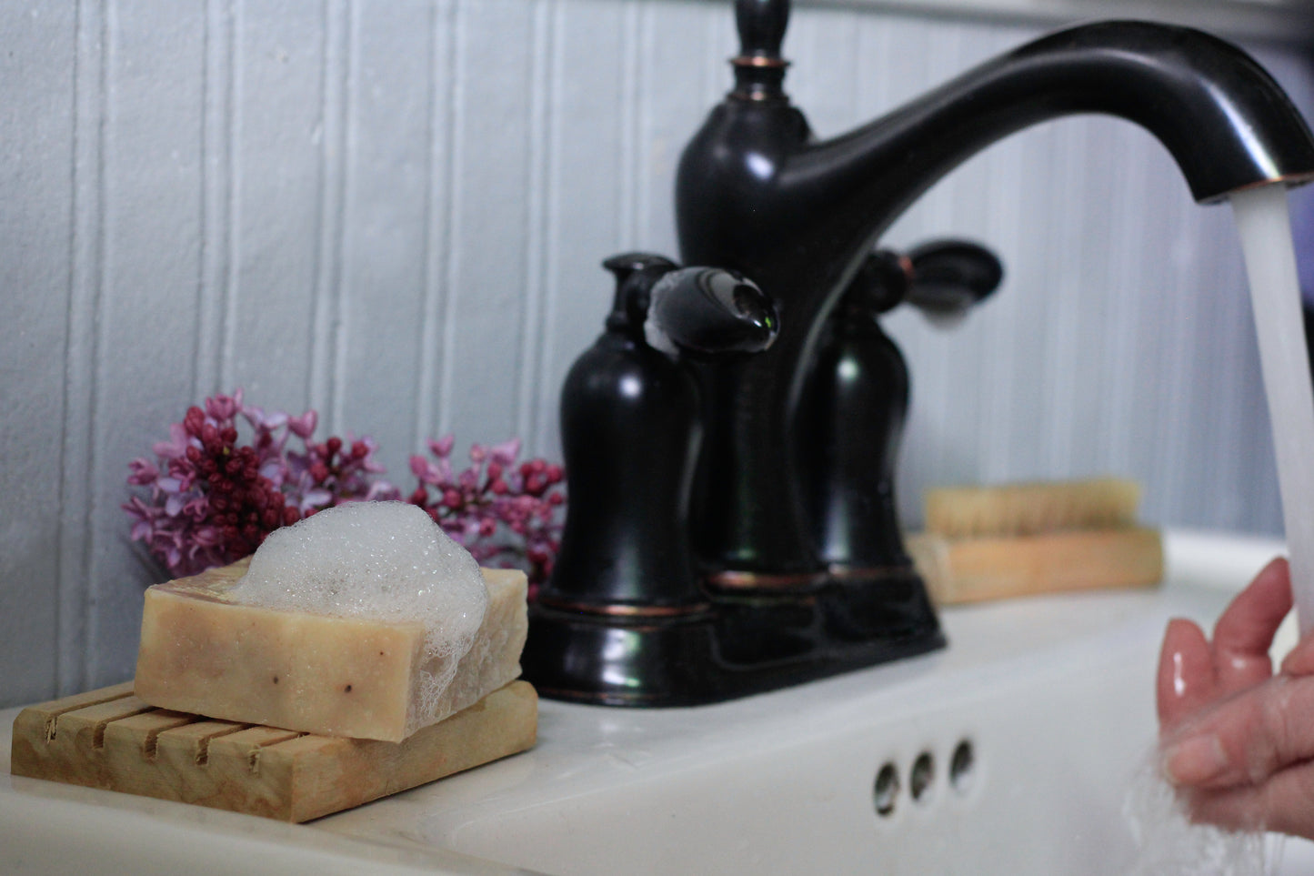 washing hands with a bar of soap at a bathroom sink with black faucet