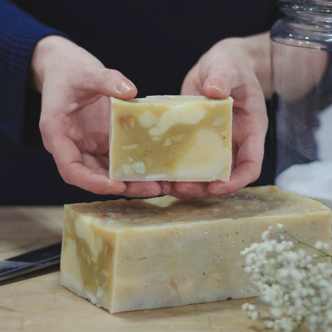 hands holding a bar of freshly cut scrappy soap