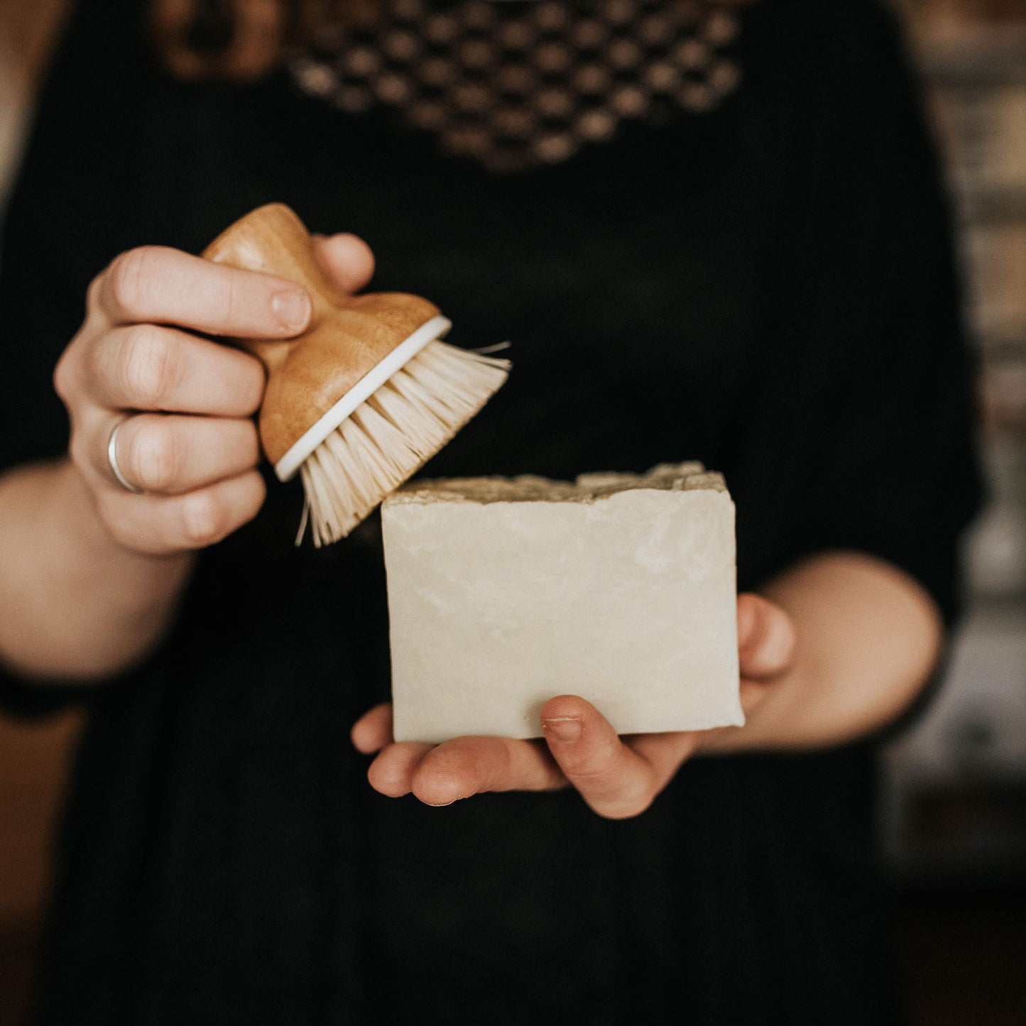 person holding a large block of solid dish soap and an eco-friendly dish scrubber