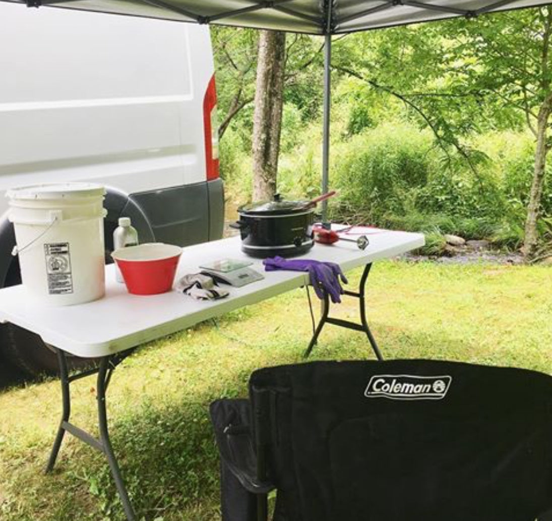 cooking soap down by the river outside a van