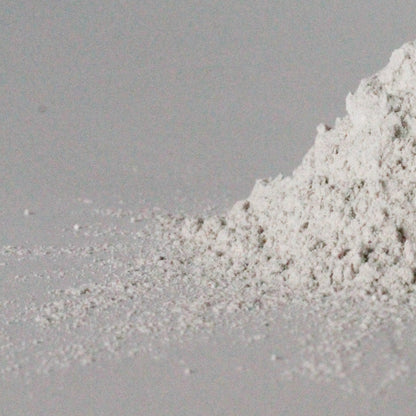 a heap of white toothpowder on a light grey background